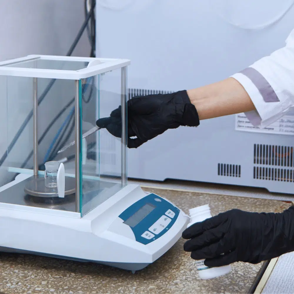 Technician using precision lab balances to measure small quantities in a laboratory setting, highlighting the accuracy and reliability of analytical scales for critical measurements