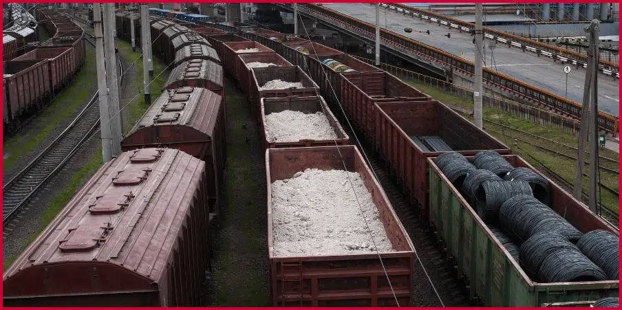 Gondola railcars loaded with bulk materials and coiled wire, showcasing their open-top design for heavy freight transport