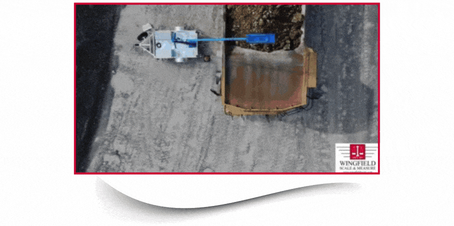 Aerial view of a mining truck passing through an industrial volumetric load scanner capturing payload volume in real-time at a quarry site