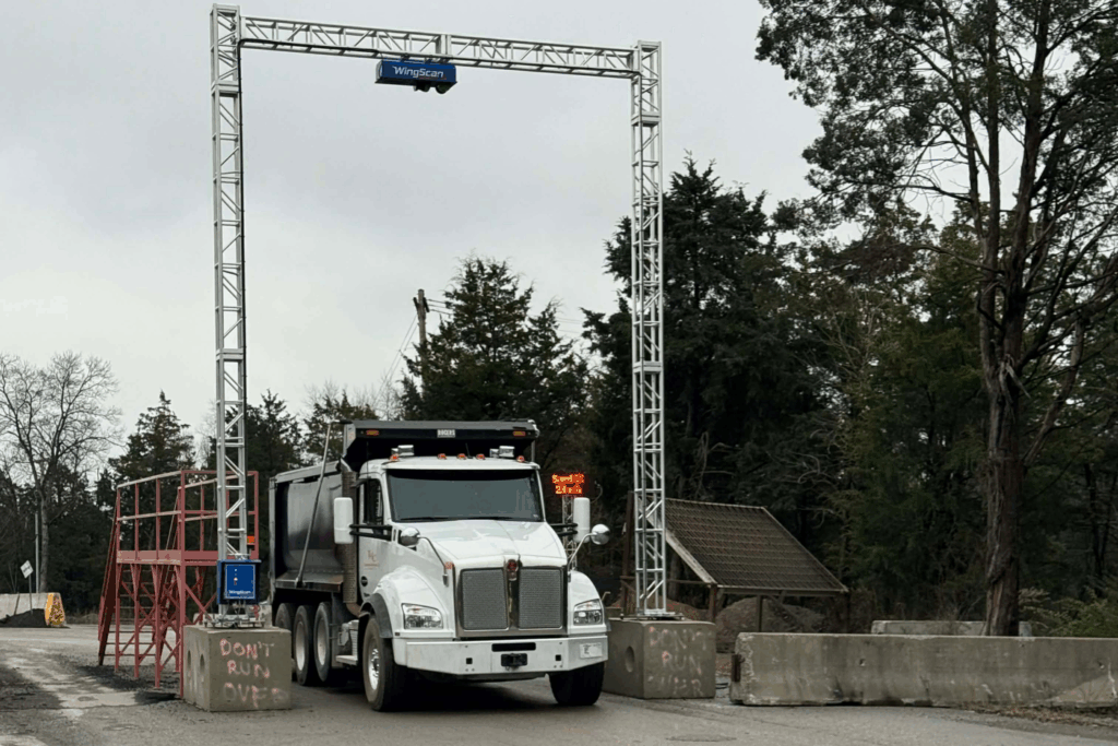 Haul truck passes under the WingScan-T LiDAR gantry for volumetric measurement capture during NTEP testing